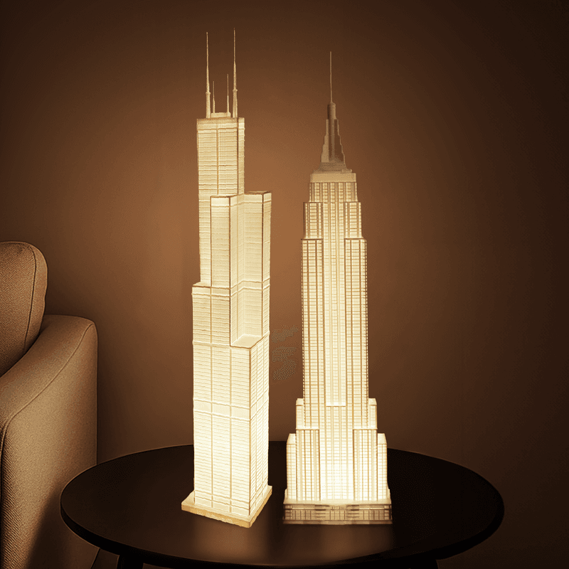 Two illuminated skyline lamps on a side table