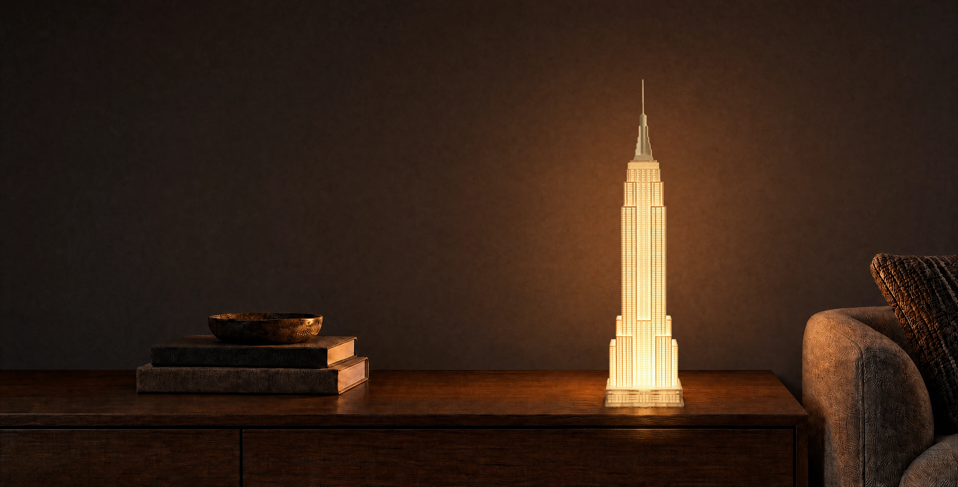 Empire State Building lamp glowing on a walnut console in a dim Brooklyn interior