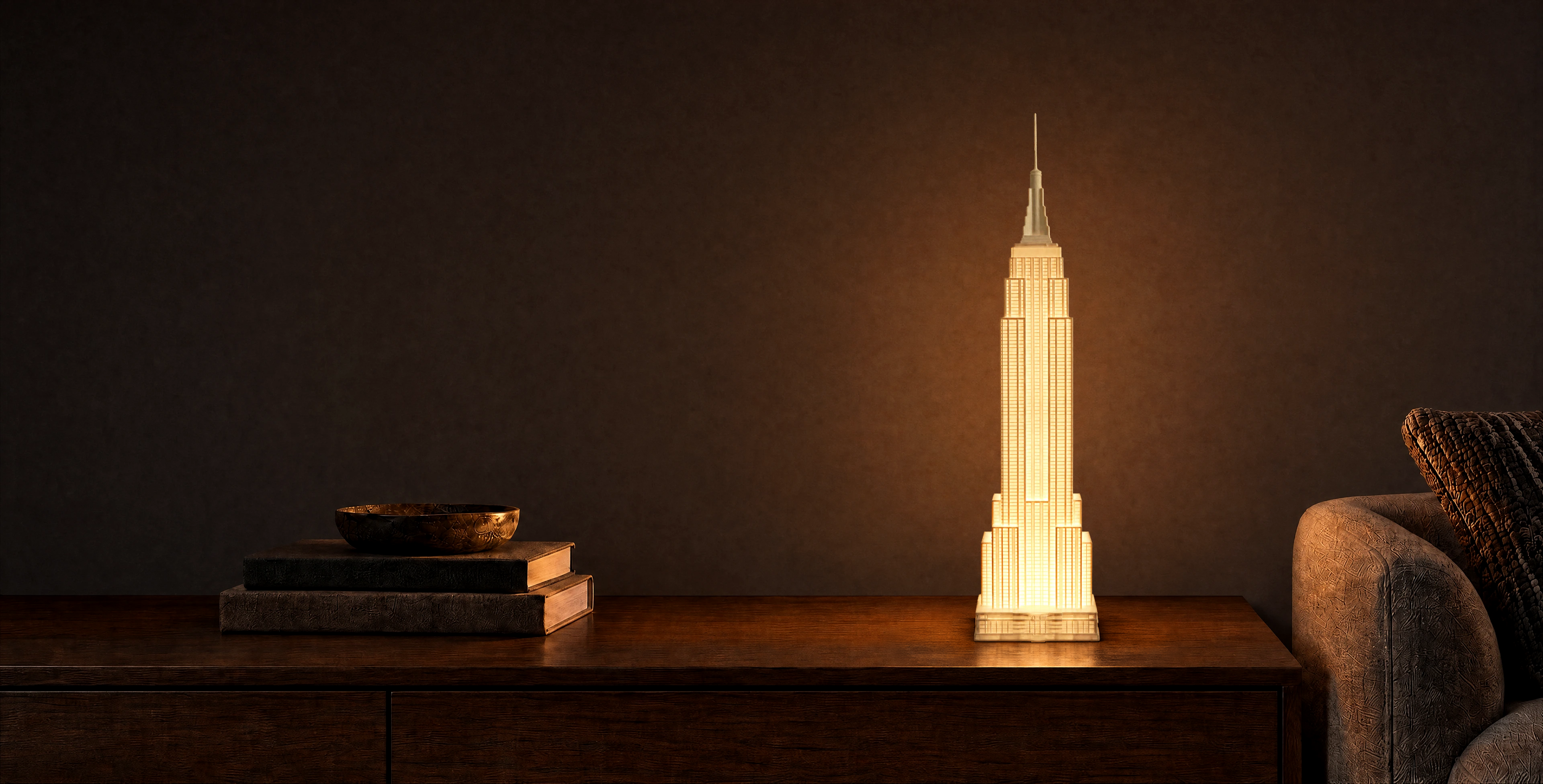 Empire State Building lamp glowing on a walnut console in a dim Brooklyn interior